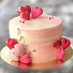 there is a pink cake with hearts on it