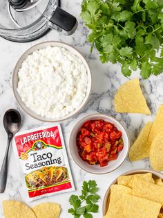 ingredients to make taco seasoning laid out on a marble counter with tortilla chips