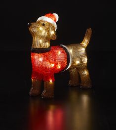 a lighted dog figurine with a santa hat and scarf on it's back