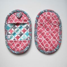 two oven mitts made out of pink and blue fabric with white circles on them