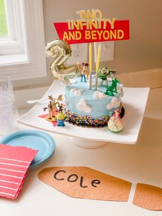 a birthday cake with an inflatable number and sign on it sitting on a table