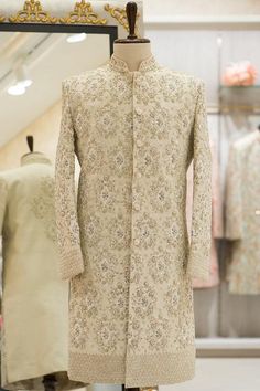 a mannequin is standing in front of a dress and coat on display at a store