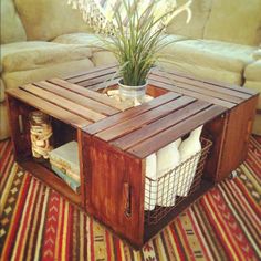 a coffee table made out of wooden crates with baskets on top and a plant in the middle