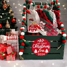 a wooden crate filled with christmas gifts next to a tree