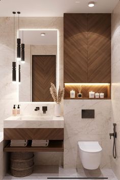 a bathroom with a toilet, sink, mirror and lights on the wall above it