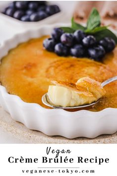 a bowl of creme brulee with blueberries on top and a spoon in it