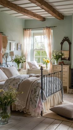 a bed room with a neatly made bed next to a dresser and window filled with flowers