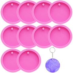 six pink trays and a keychain with a purple disc on the bottom