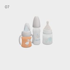 three baby bottles sitting next to each other in front of a white background with the number seven on it