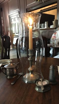 a candle is lit in a glass vase on a table