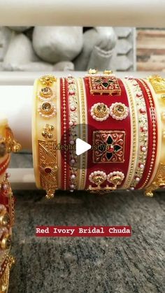 red and gold bridal bracelets on display in front of a white vase with flowers