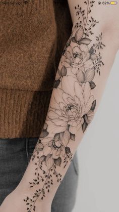 a woman's arm with black and white flowers on the left side of her arm