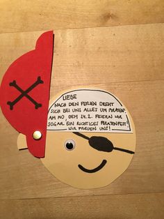 a piece of paper cut out to look like a pirate with a red hat and eye patch