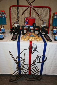 a hockey themed table is set up with popcorn and other items for the game on it