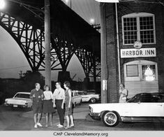 an old black and white photo of three women standing in front of a harbor inn