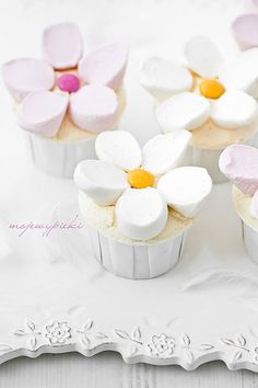 four cupcakes decorated with white and pink flowers