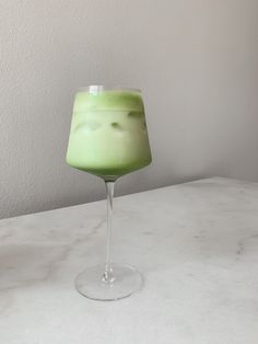 a green drink sitting on top of a white counter