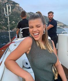 a woman is smiling while sitting on a boat