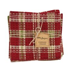 two red and green plaid napkins with a tag on the front, tied together