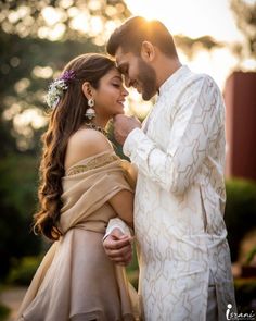 a man and woman standing next to each other in front of the sun at their wedding