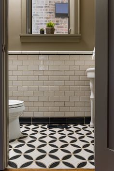 an open door leading to a bathroom with black and white tile