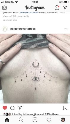 the back of a woman's stomach with an eye tattoo on her left side