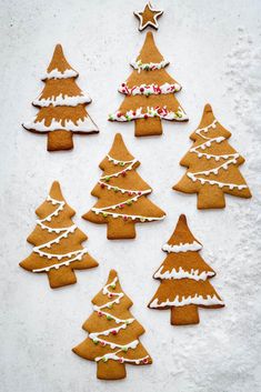 christmas tree cookies are arranged in rows on a white surface