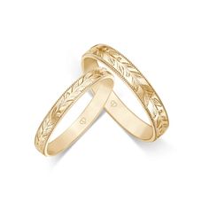 two gold wedding bands with engraved leaves on each band, set against a white background