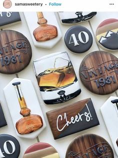 some very pretty decorated cookies on top of a table with wine glasses and whiskey bottles