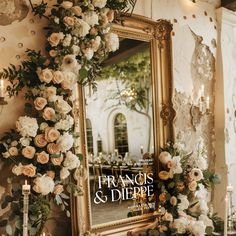 a mirror with flowers on the wall and candles in front of it that reads frances & dippe