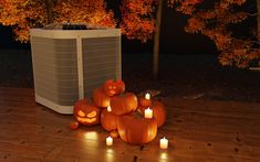 a group of pumpkins sitting on top of a wooden floor next to an air conditioner