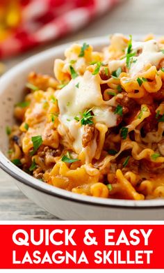 a white bowl filled with pasta and cheese on top of a wooden table next to a red sign that says quick & easy lasagna skillet