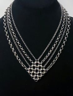 This diamond-shaped chainmaille statement necklace is an ideal combination of novelty and practicality, as it's a stand-out piece, yet can be worn with most pieces within your wardrobe. The cable chains are stainless steel (as is all of the necklace). It comes with a large lobster claw clasp and extender chain that allows you to adjust the length based on what you're wearing. In therms of measurements, it's roughly 15.75 inches around and the extender chain is 2.5 inches. Ships within 1-2 busine Silver Chainmail Necklace, Chainmaille Jewelry Patterns, Chainmail Patterns, Leather Statement Necklace, Jump Ring Jewelry, Chainmail Necklace, Silver Statement Necklace, Chainmail Jewelry, Chain Maille Jewelry