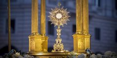 an ornate gold alter with white flowers and greenery in front of a large building