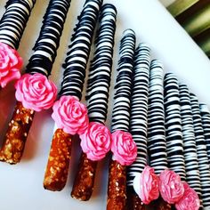 several black and white striped straws with pink flowers on them are lined up next to each other