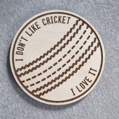 a wooden badge that says, i don't like cricket but i love it