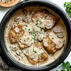 chicken with mushroom gravy in a crock pot on top of a table