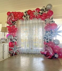 the balloon arch is decorated with pink, black and white balloons