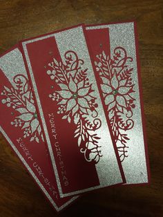 three red and silver cards on a wooden table