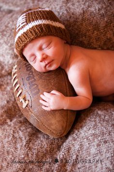 a baby sleeping on top of a football