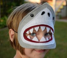 a young boy wearing a shark mask on top of his head