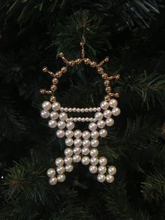 a christmas ornament with pearls hanging from it's side on a tree