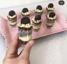 someone is holding up some desserts on a pink tray