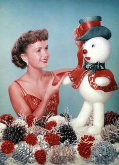 an old photo of a woman with a snowman