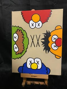 an image of some cartoon characters painted on canvases with wood easel holder and black background