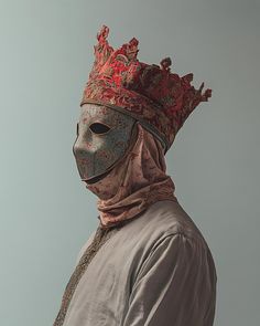 a man wearing a mask with a red crown on his head and a scarf around his neck