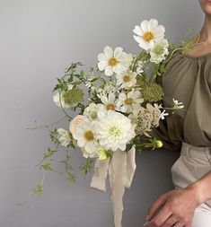 a woman holding a bouquet of white flowers