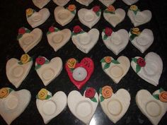 a table topped with lots of white heart shaped cakes covered in frosting and flowers