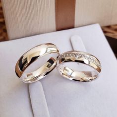 two wedding rings sitting on top of a white napkin