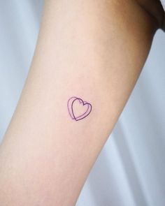 a small heart tattoo on the arm